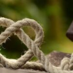 Bowline Knot - Brown Rope Tangled and Formed Into Heart Shape on Brown Wooden Rail