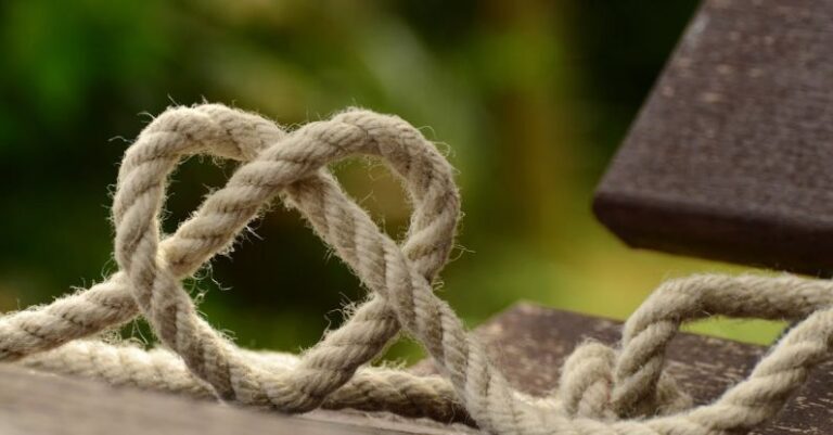 Bowline Knot - Brown Rope Tangled and Formed Into Heart Shape on Brown Wooden Rail
