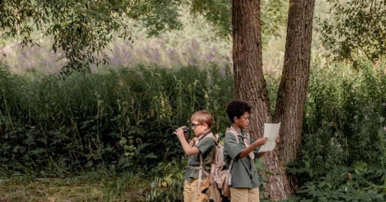 Orienteering - Boys Standing on Grass Field Near Brown Tree