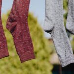 Rope Care - Multicolored socks drying on rope with clothespins in garden