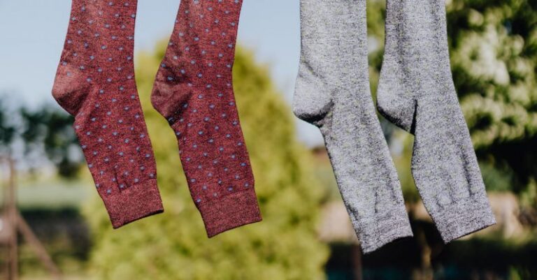 Rope Care - Multicolored socks drying on rope with clothespins in garden