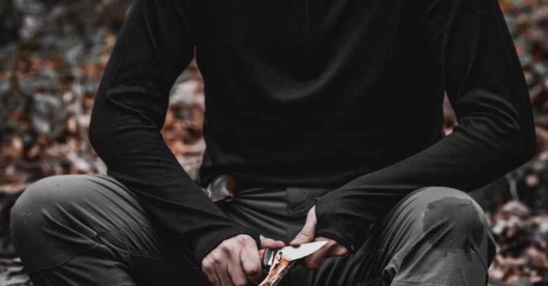 Survival Mistakes - A man sitting in the woods with a knife