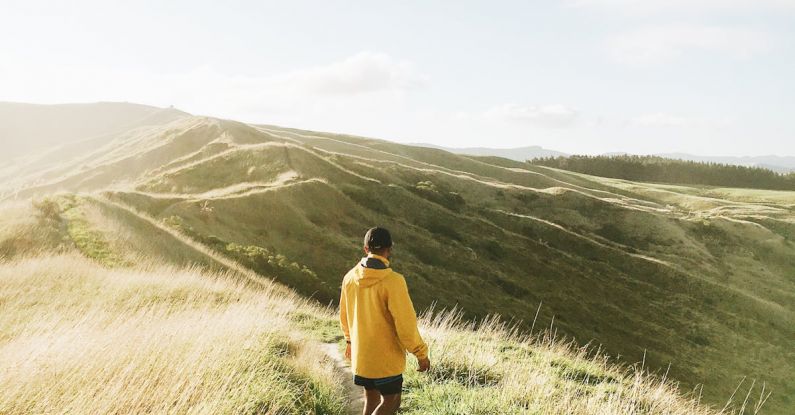 Solo Hiking - Back View of a Man Standing in a Footpath Towards the Hills