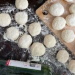 Cooking Techniques - A table with dough, flour and a bottle of wine