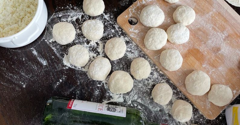 Cooking Techniques - A table with dough, flour and a bottle of wine